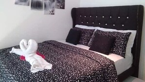 A hotel room with a bed, a headboard, and three wall-mounted pictures.