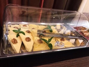 Un bufé con varios quesos y nueces.