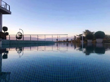 Una piscina al aire libre, sillones reclinables de piscina