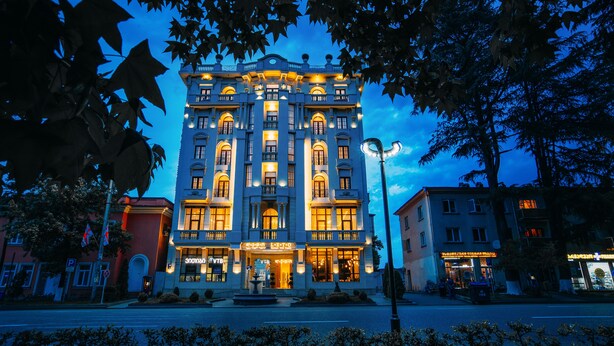 A historic building with multiple floors, large windows, and a central entrance. - LETO Boutique Hotel (Zugdidi)