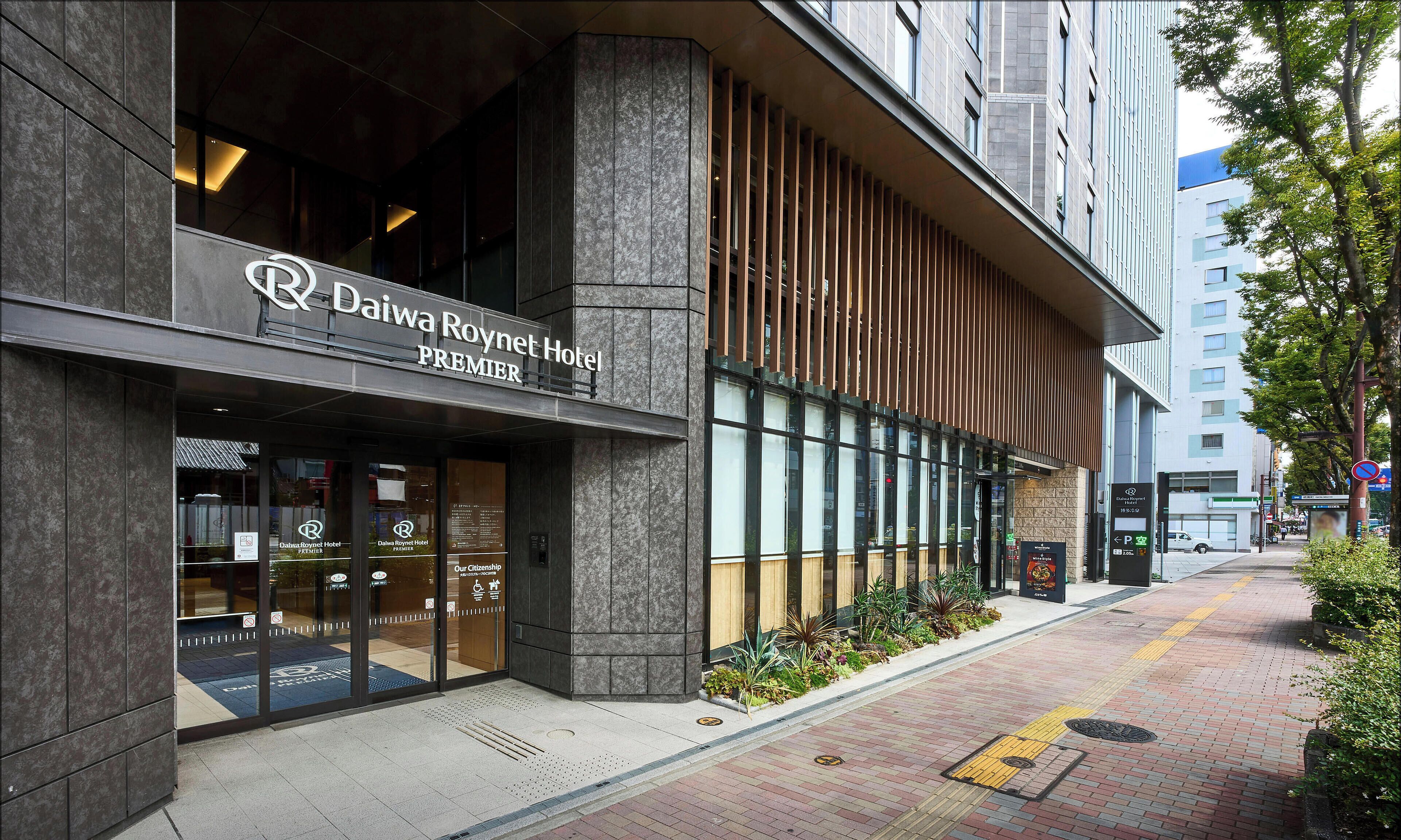 The exterior of the Daiwa Roynet Hotel Premier with a modern facade, large windows, and a visible entrance.