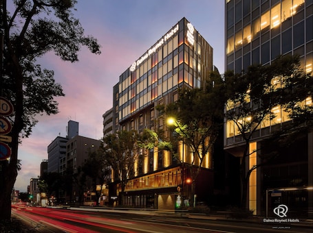 A modern hotel building with a prominent sign, large windows, and a well-lit facade.. Daiwa Roynet Hotel Hakata Reisen PREMIER
