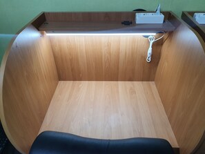 Un bureau en bois doté d’un plateau plat, d’une multiprise et d’un câble.
