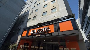 A hotel with a modern facade, a prominent orange sign, and a clear sky in the background. - APA Hotel Sagamihara Hashimotoeki Higashi (Sagamihara)