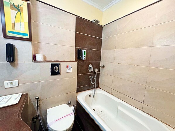 A bathroom with a bathtub, toilet, and hand sanitizer dispensers.