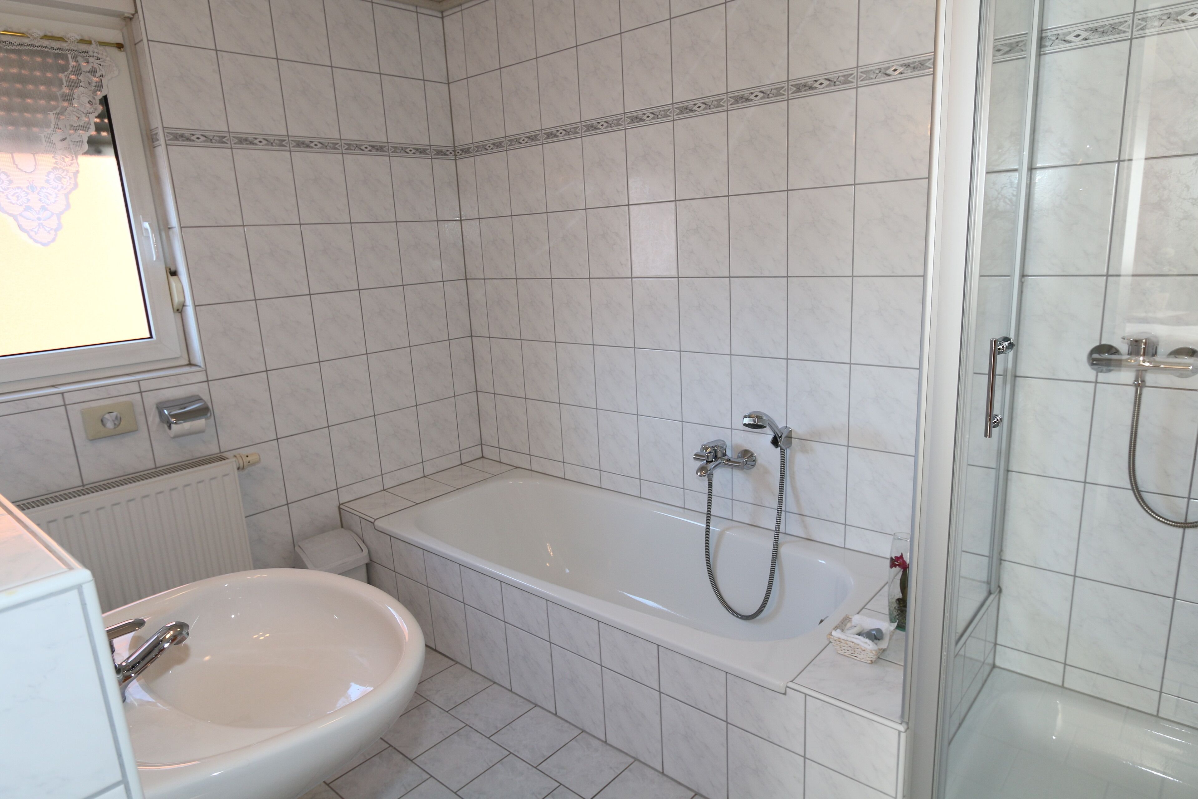 A bathroom with a bathtub, a shower, and a sink.