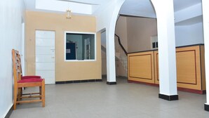 A spacious interior with a wooden chair, a white door, and a window. - Sunway Hotel Nairobi - YOHOH (Nairobi)