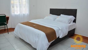A hotel room with a bed, a chair, and a window. - Sunway Hotel Nairobi - YOHOH (Nairobi)