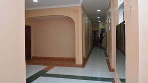A corridor with cream-colored walls and a tiled floor. - Sunway Hotel Nairobi - YOHOH (Nairobi)