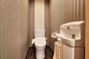 A compact bathroom with a toilet, a towel, and a sink. - Churaya -Yaedake with Japanese Garden- (Motobu)