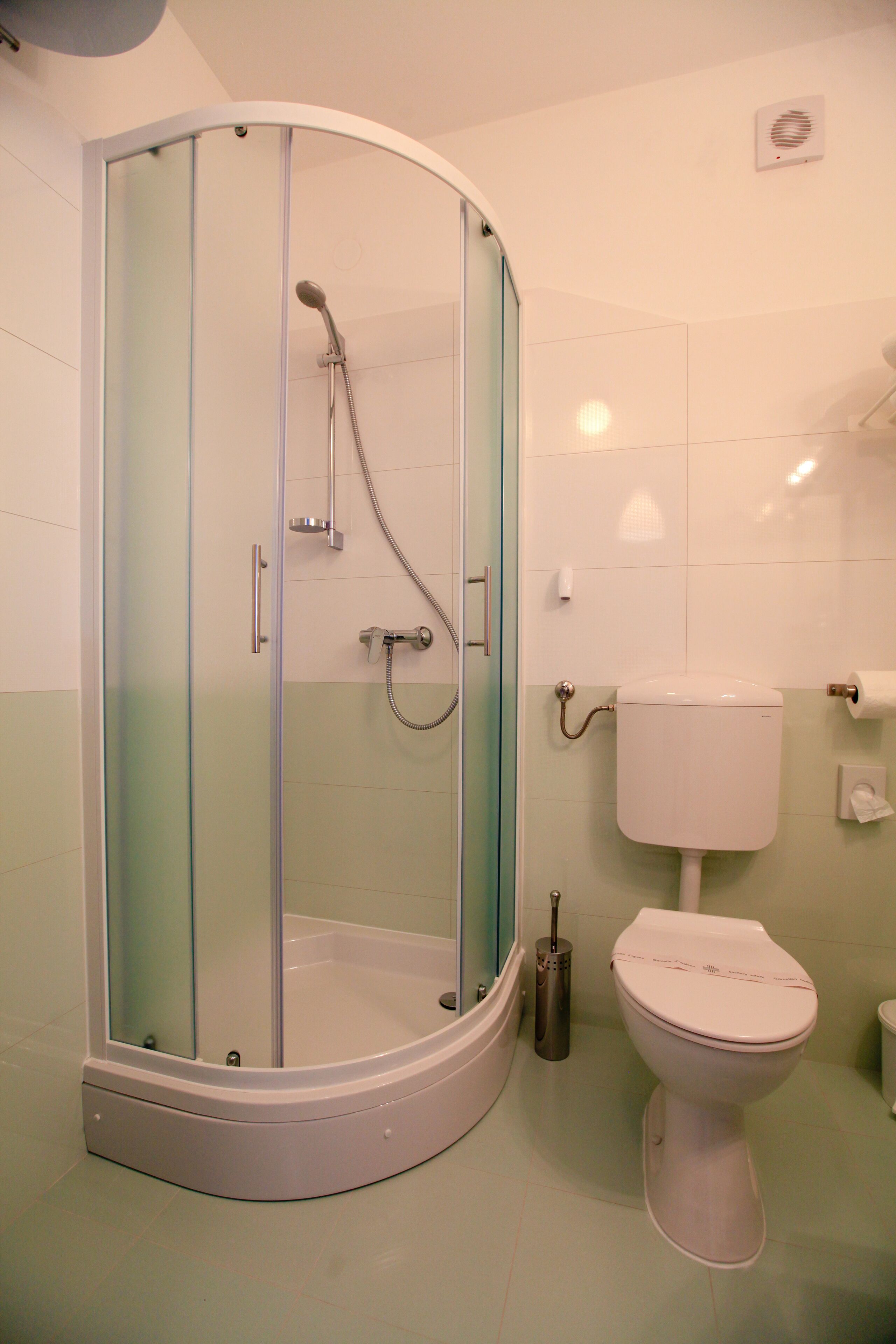 A bathroom with a glass-enclosed shower, a toilet, and a bidet.