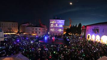 Gran evento al aire libre con un escenario y una multitud.