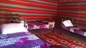 A room with three beds, each with patterned bedding and a headboard. - Rum Road - Hostel (Wadi Rum)