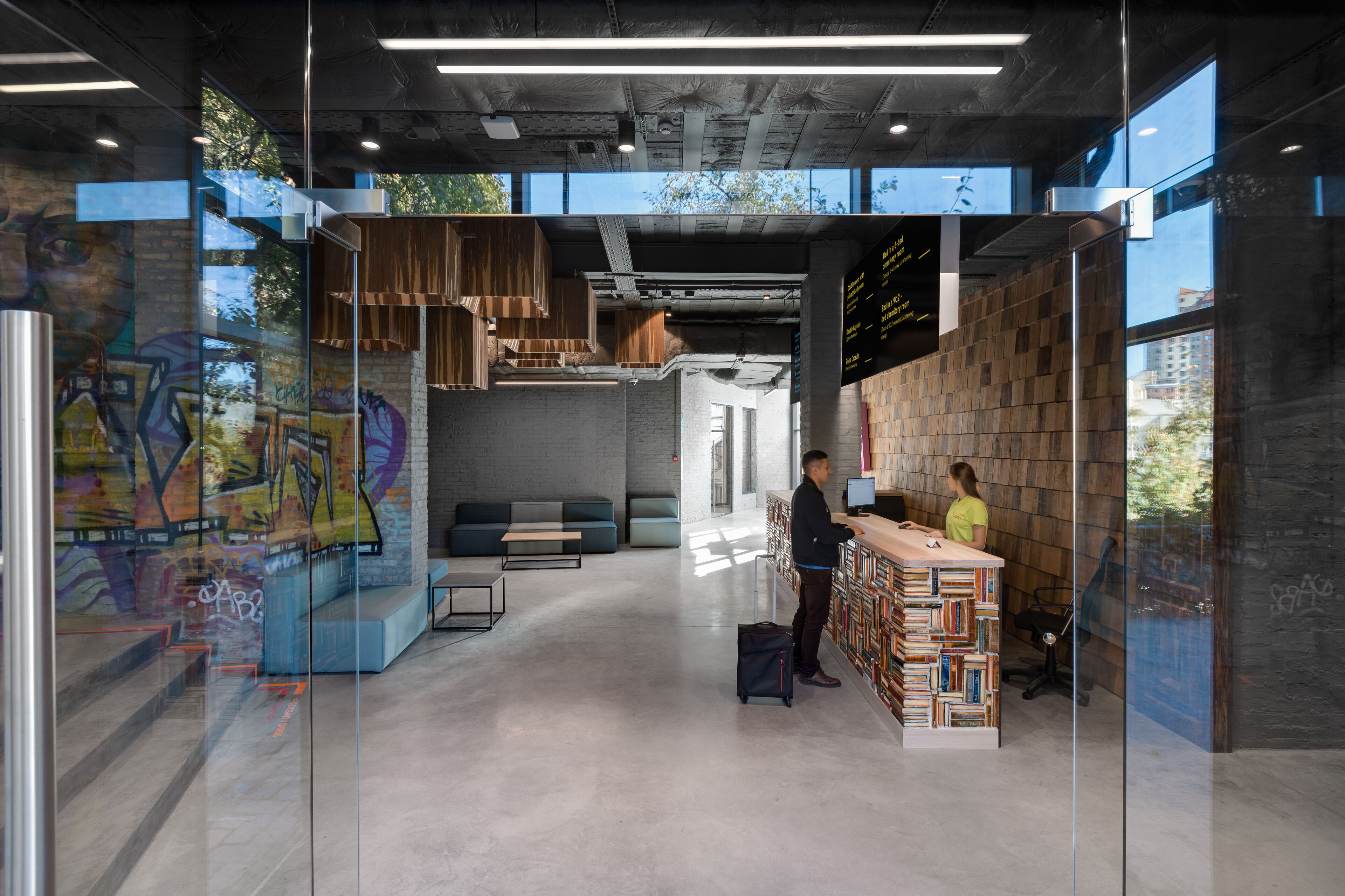 A modern interior with a reception desk, a seating area, and a wall with a bookshelf.