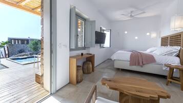 Une chambre moderne avec un grand lit, une télévision et un bureau en bois.