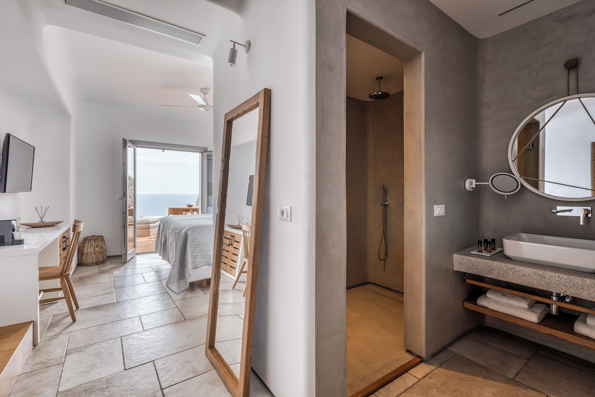 A modern bathroom with a large mirror, a round mirror, a bathtub, and a sink with a countertop.