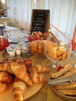 A breakfast buffet with croissants, pastries, and beverages. - Albergo Locanda Maria (Ameglia)