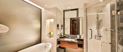 A modern bathroom with a freestanding bathtub, a glass-enclosed shower, and a vanity with a marble countertop.