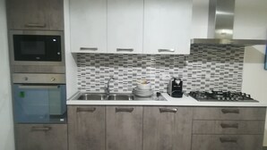 A kitchen with a microwave, stove, sink, and cabinets.