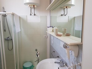 A modern bathroom with a glass-enclosed shower, a white sink, and a vanity with a mirror. - Dimora dell'Artista 2 (Lecce)