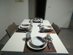 A dining table set with plates, cups, and cutlery, with chairs around it. - Dimora dell'Artista 2 (Lecce)