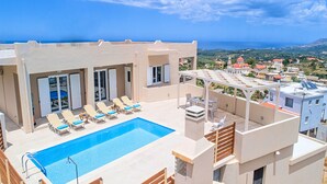 A rooftop pool with lounge chairs, a pergola, and a view of the sea and town. - Villa di Giorgio Heated Pool (Apokoronas)