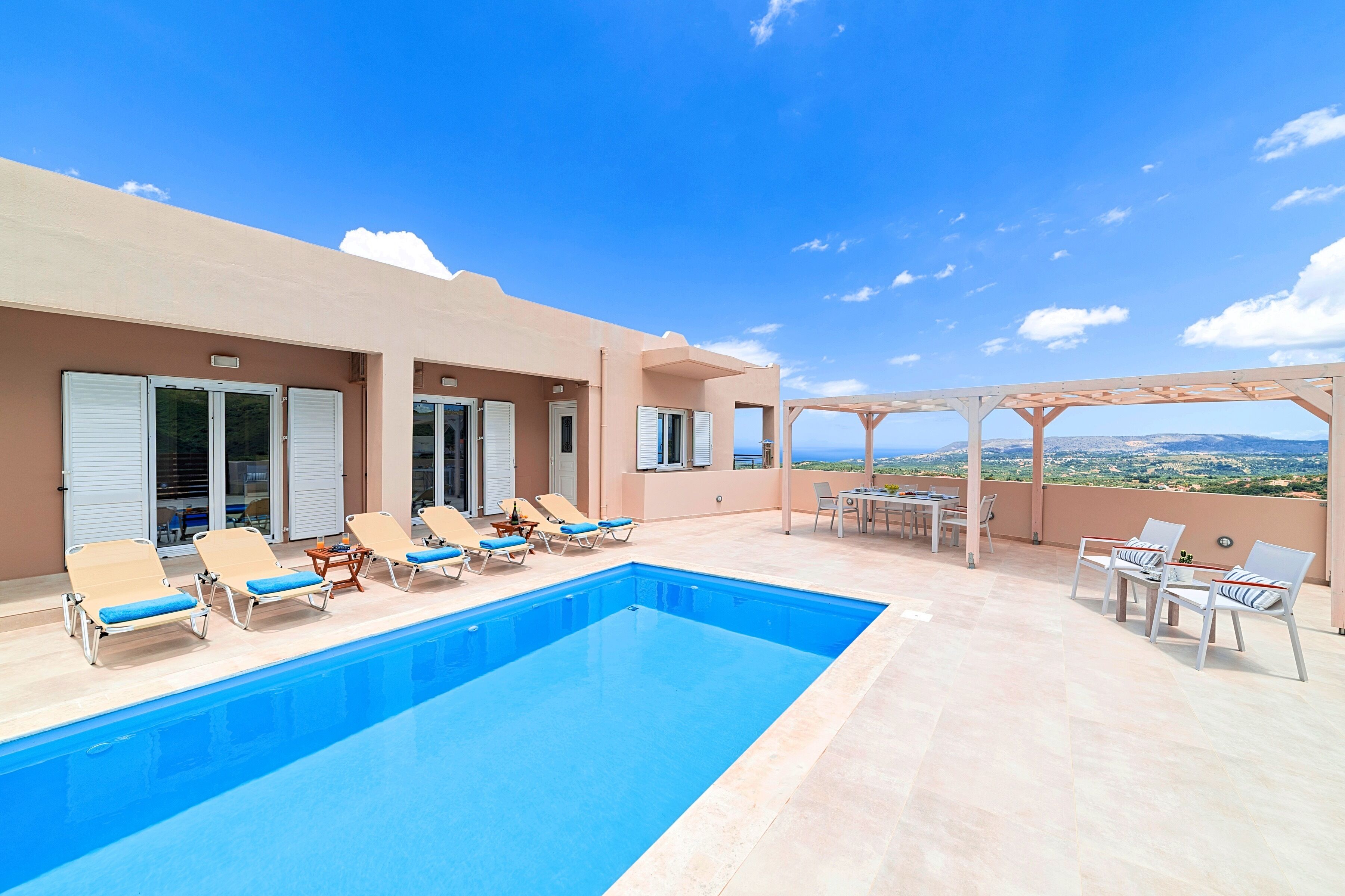 A rooftop pool area with lounge chairs and a pergola.