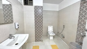 A bathroom with a sink, toilet, and shower. - Hotel Ashapura Palace by Sky Stays (Nathdwara)