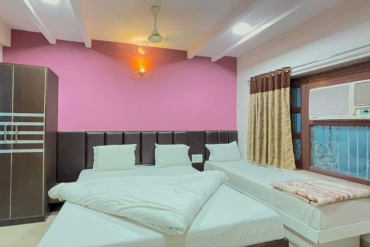 A bedroom with a bed, a wardrobe, a ceiling fan, and a window with curtains.