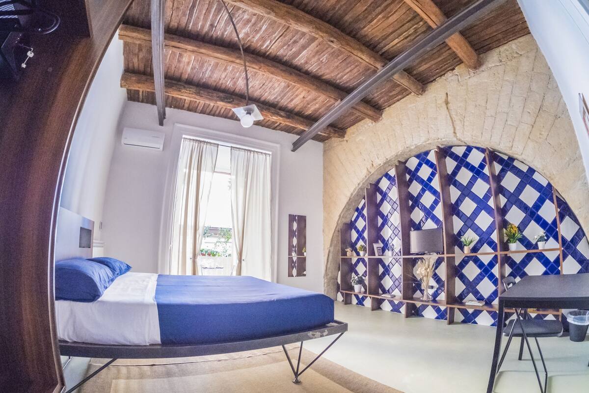 Une chambre à coucher avec un lit, un bureau et une fenêtre.