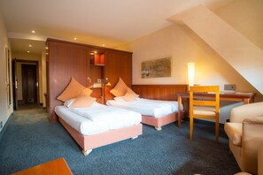 A hotel room with two beds, a desk, a chair, and a large wardrobe. - Zum Roten Bären (Freiburg im Breisgau)