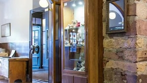 A stone wall with a wooden door, a wooden bench, and a glass display case with items. - Zum Roten Bären (Freiburg im Breisgau)