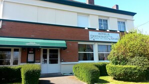 Un bâtiment à deux étages sur lequel on peut lire l’inscription suivante : « Hôtel Restaurant du Hangest - Sur - Somme ».