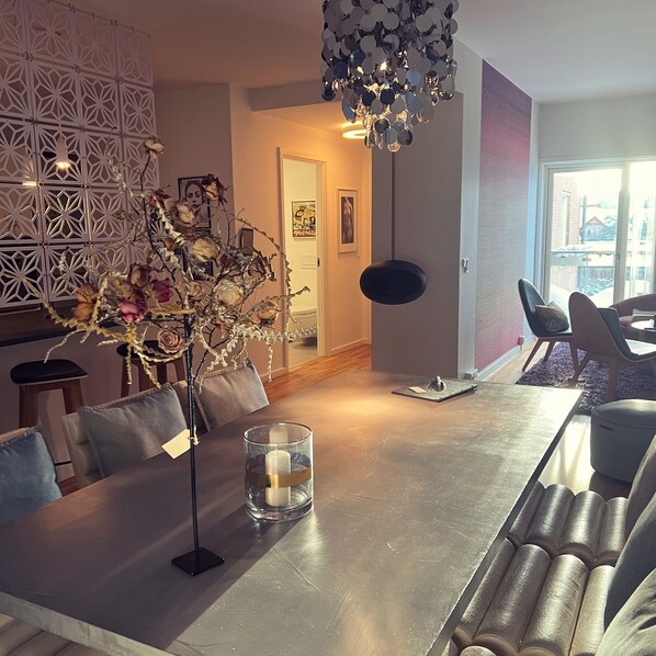A modern dining area with a glass table, candles, and a decorative plant. - Mortens Kro Boutique Hotel (Aalborg)