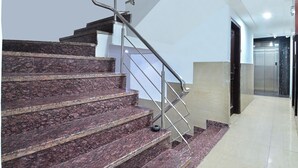 Una escalera con barandilla de metal que lleva a un ascensor.