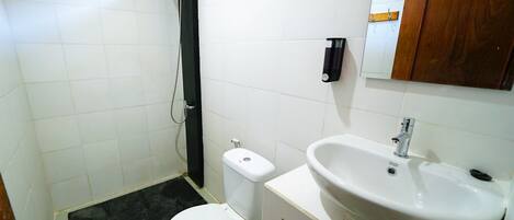 Un baño con inodoro, lavabo y ducha.