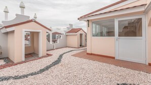 Un quartier résidentiel composé de plusieurs maisons présentant des styles architecturaux différents, notamment une maison dotée d’une grande porte-fenêtre coulissante et d’un toit recouvert de tuiles.