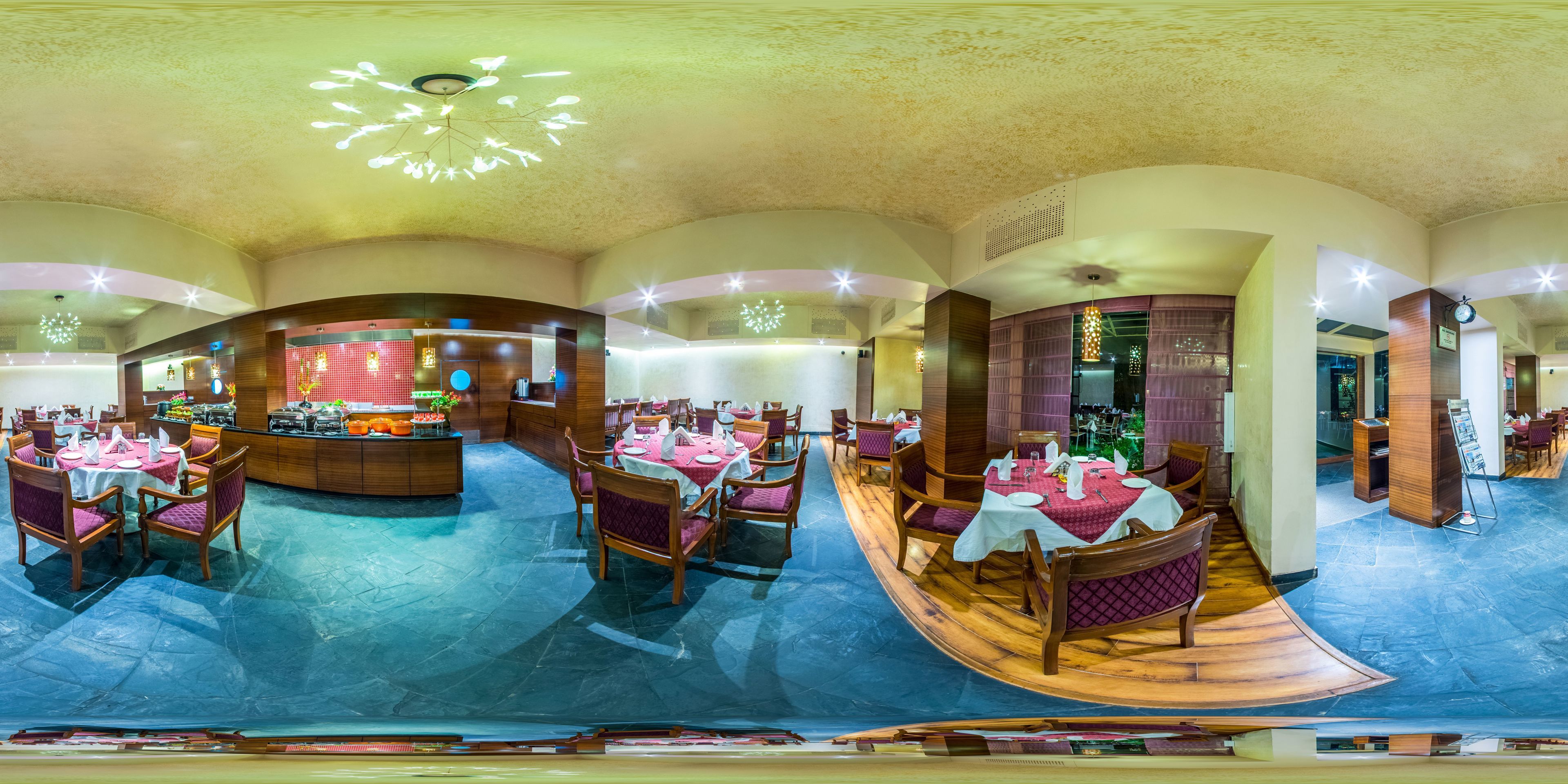 A restaurant with round tables and chairs, a bar area, and a ceiling with decorative lighting.