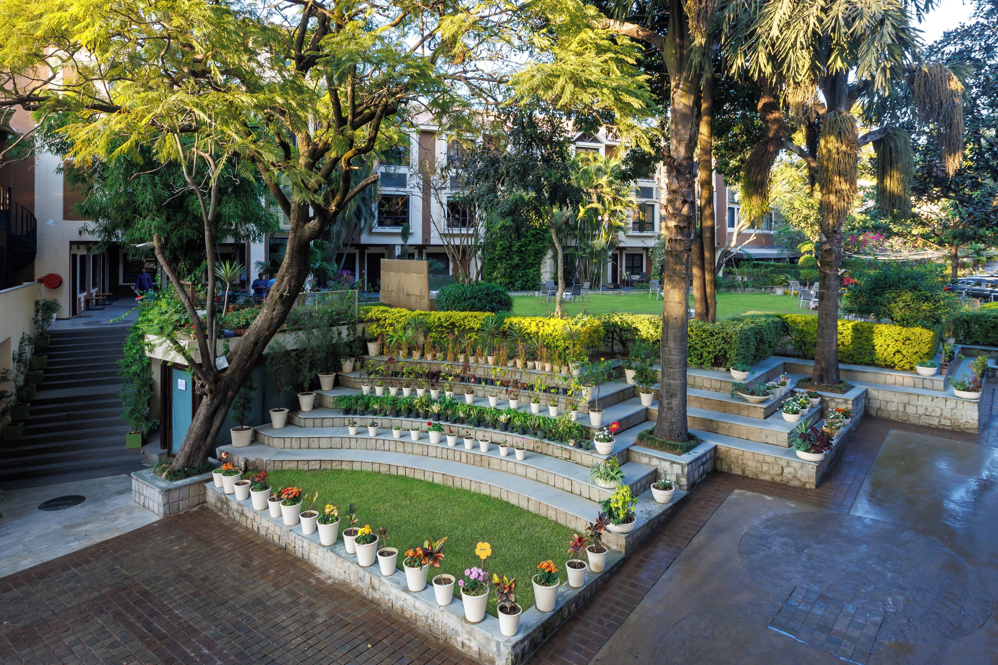 Une cour aménagée avec des jardinières en terrasses et une variété de plantes en pot.