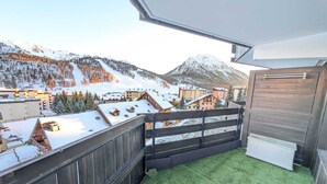 A balcony with a view of a snowy mountain and buildings. - Cozy studio 4 pers, pets allowed, parking, near slopes (Montgenèvre)