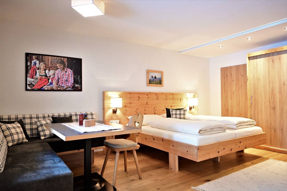 Une chambre à coucher moderne avec un lit en bois, un bureau et un canapé.