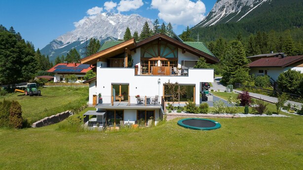 A two-story chalet with a balcony, a swimming pool, and a view of mountains. - Residence Martha (Biberwier)