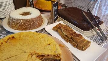 A table with various desserts including a cake with a white topping, a chocolate dessert, and a pie with a golden crust.