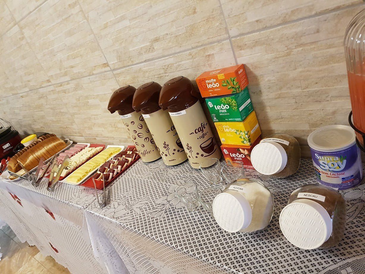 A buffet table with various food items and beverages, including coffee and juice cartons.