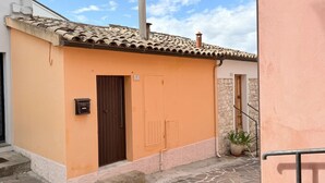 A building with a tiled roof, a door marked with the number 7, and a small potted plant. - N079 - Numana, delightful sky-earth in the historic center (Numana)