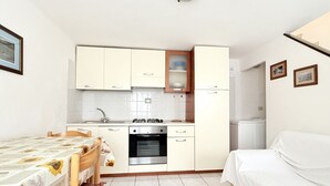 A compact kitchen with a stove, oven, and white cabinets. - N079 - Numana, delightful sky-earth in the historic center (Numana)