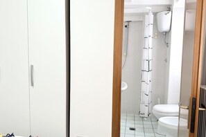 Un bagno con doccia, wc e lavandino bianco.