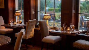 Un espace repas avec des tables et des chaises en bois, ainsi que des lampes à la lumière des bougies.