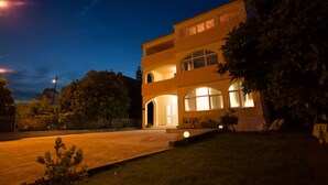 A two-story building with a large arched entrance and multiple windows. - Apartments Kampanel (Kastela)