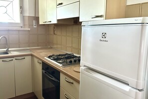 Een koelkast, een oven, eettafels